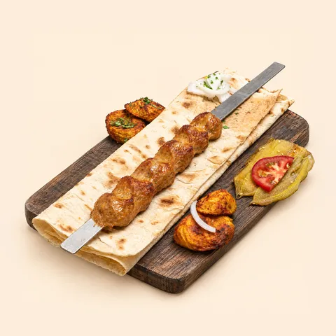 Chicken kebab on lavash on a wooden board