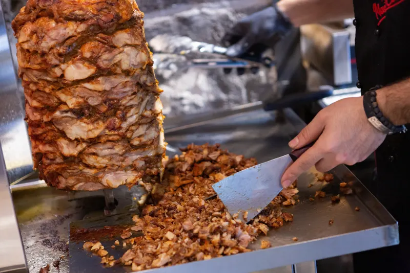 Chef carving meat from the doner